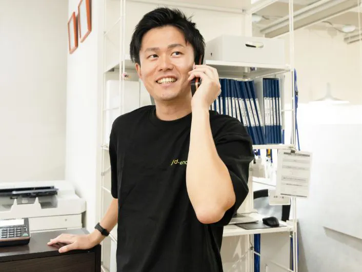 オフィス内で電話をしながら業務を行っている様子。