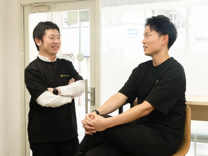 事務所のカウンター席でスタッフからの相談を受けている様子。