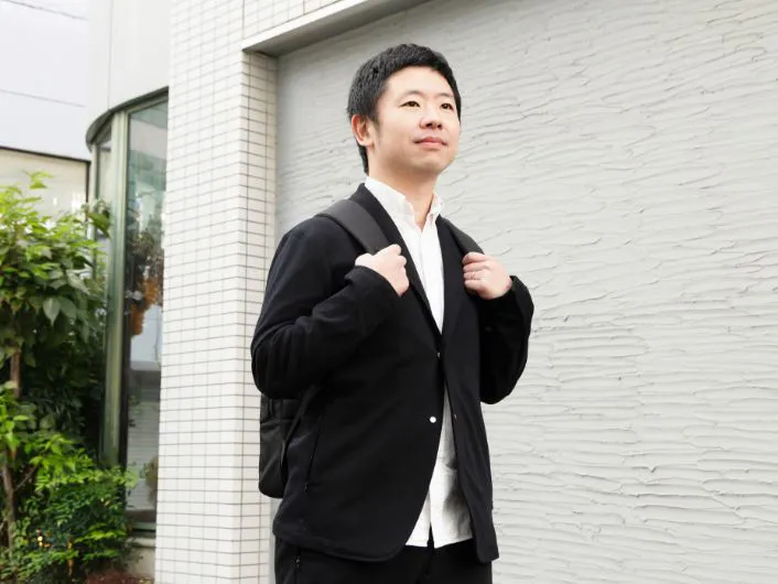 周知活動を終え、リュック姿で事業所に戻る様子。