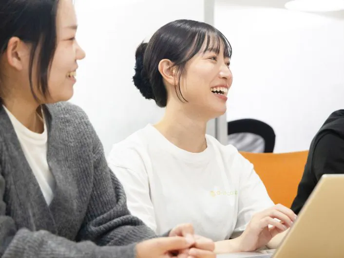 終礼でチームメンバーがノートパソコンを使いながら打ち合わせをしている様子。