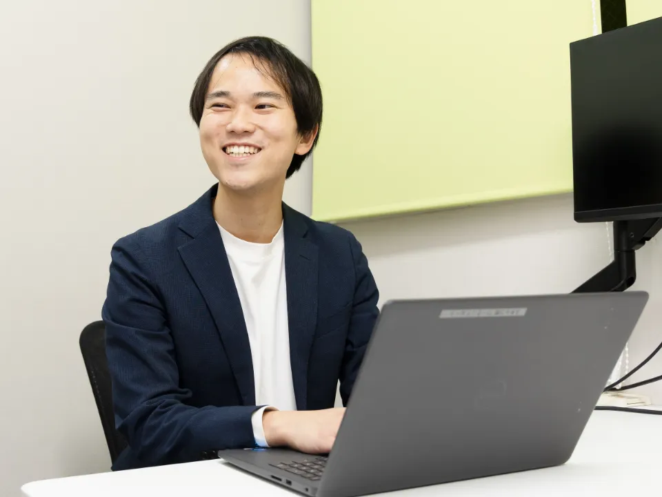 S.S.さん仕事風景。オフィスでノートパソコンを使って事務作業をしている様子