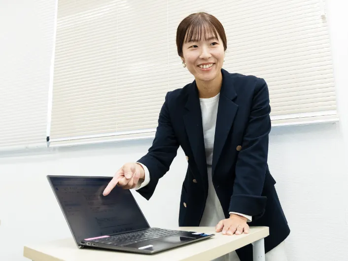 模擬職場でノートパソコンを指しながら業務指示を出す職業指導員