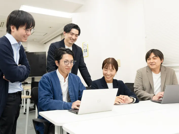 職業指導員がパソコンを使いながら複数人で業務の打ち合わせをしている様子