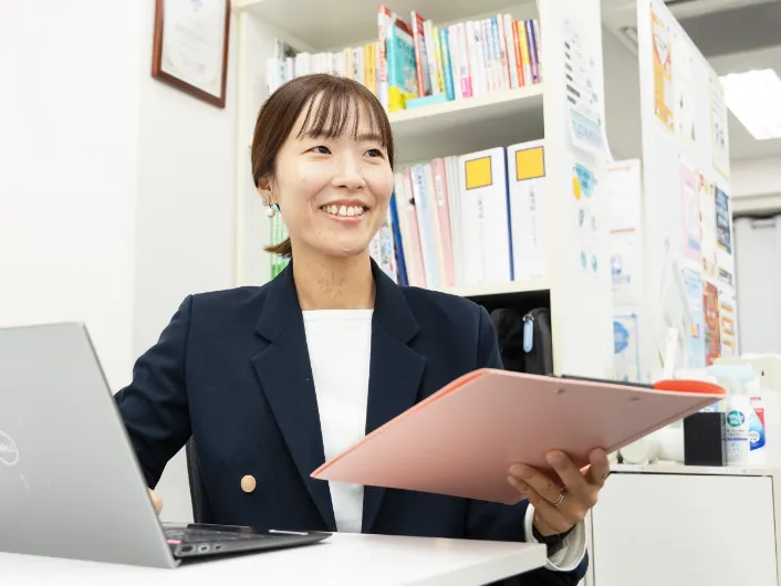 デスクでパソコンと書類を確認している様子